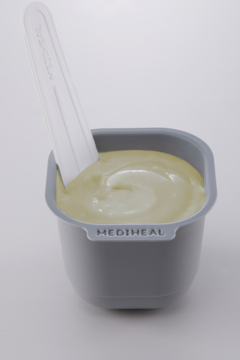 Mediheal Derma Modeling Pack Vitamin Brightening, rozświetlający krem w szarej misce z aplikatorem. Zbliżenie.