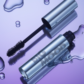 Wodoodporny tusz e.l.f. Big Mood, otwarta metaliczna tuba i szczoteczka klepsydra, na mokrym fioletowym tle.