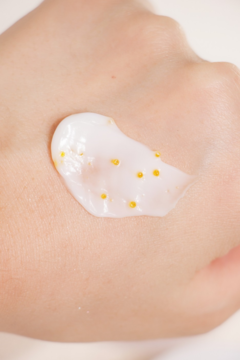 Krem rozświetlający d’Alba White Truffle z kapsułkami Vita-Cera Glow na dłoni, zbliżenie.