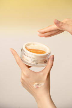 d'Alba White Truffle Double Serum & Cream, otwarty słoik w dłoniach, widoczne dwie warstwy i testura na ręce.