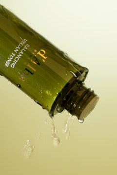 d'Alba Balancing Vegan Toner, ciemnozielona butelka z kapiącym płynem, ukazująca nawilżającą formułę z truflą.