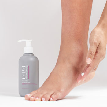 OPI Moisture Mission krem nawilżający do pedicure w szarej butelce z pompką, aplikowany dłonią na stopę.