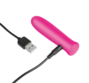 Różowy, silikonowy wibrator, widok z boku, podłączony do czarnego kabla USB do ładowania, na gradientowym tle.