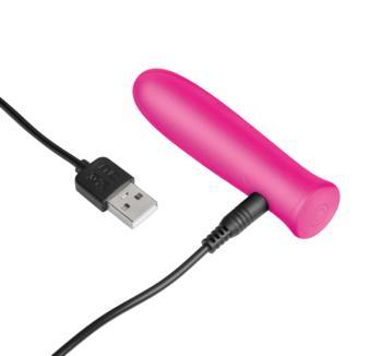 Różowy, silikonowy wibrator, widok z boku, podłączony do czarnego kabla USB do ładowania, na gradientowym tle.