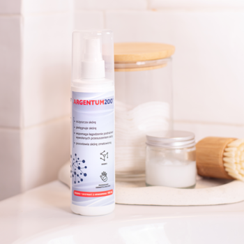 Biały aerozol Argentum200 Srebro 150ml w butelce ze spryskiwaczem do pielęgnacji skóry, na blacie w łazience.