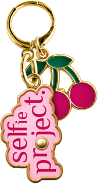 Złoty brelok z dwoma emaliowanymi zawieszkami: wiśnie i różowy tag z napisem 'selfie project.', widok z przodu.