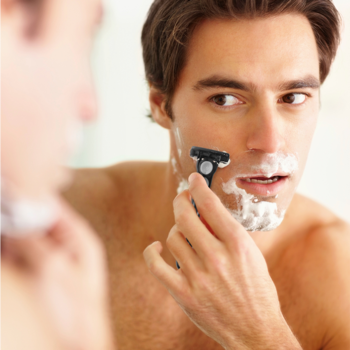 Mężczyzna goli twarz maszynką BIC Hybrid Flex 4 z czterema ostrzami, z pianką, patrząc w swoje odbicie w lustrze.