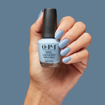 Błękitny, błyszczący lakier do paznokci O.P.I. w butelce, trzymany w dłoni z pomalowanymi paznokciami.