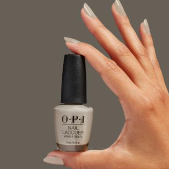OPI Nail Lacquer w kolorze jasnego beżowo-szarego, trzymany w dłoni z paznokciami pomalowanymi na ten sam odcień.