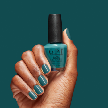 Ciemnoskóra dłoń trzyma butelkę lakieru OPI w turkusowym kolorze, paznokcie pomalowane na ten sam odcień.
