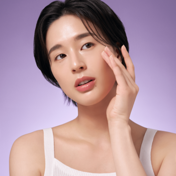 Kobieta z gładką cerą dotyka policzka. Promuje przeciwzmarszczkowy krem PURITO SEOUL z retinolem.