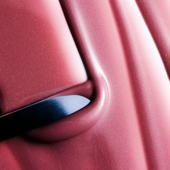 Zbliżenie aplikatora różowego balsamu do ust Fluff Candy Lip Balm Vanilla Glazed Donut w tubce.