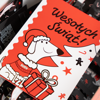 Kalendarz adwentowy dla psa: świąteczna kartka z jamnikiem w czapce Mikołaja i prezentem. Napis 'Wesołych Świąt!'