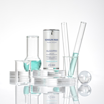 Biały krem pod oczy SENSUM MARE ALGOPRO, neurokompleks z PDRN, w butelce wśród laboratoryjnych probówek z niebieską cieczą.