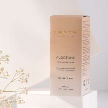 Beżowe pudełko Sensum Mare Algotone 02 Natural Multi-care kremu BB z SPF 15, na jasnym tle z kwiatami.