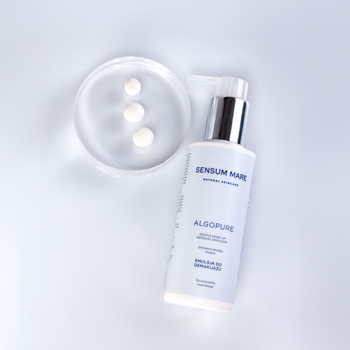 Biała emulsja do demakijażu Sensum Mare Algopure z pompką i trzema kroplami w szalce Petriego, widok z góry.
