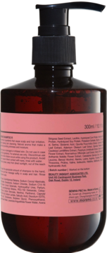 Tył ciemnobrązowego szamponu do włosów suchych i osłabionych, z czarną pompką. Widoczna różowa etykieta ze składnikami, 300ml.
