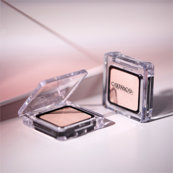 Dwa rozświetlające cienie Catrice 470 Fairytale Dust w przezroczystych opakowaniach, jeden otwarty na jasnym tle.