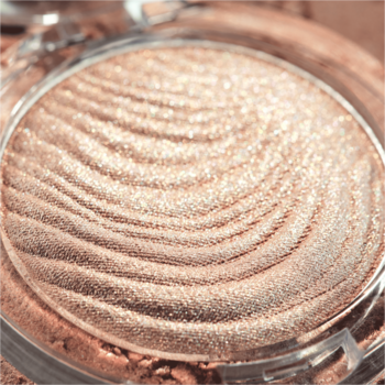 Złocisty rozświetlacz Catrice Aura Glam Moonlit Sand, okrągły, z falistym wzorem i perłowym połyskiem.