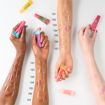 Swatche wielu błyszczyków essence JUICY BOMB, w tym miodowo-złoty 109 Bee Mine, na ramionach o różnych karnacjach.