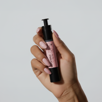 Wzmacniająca odżywka COOLNAILS Marshmallow Pen, czarny aplikator w dłoni z różowymi paznokciami.
