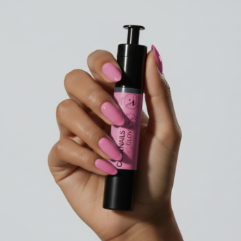 Dłoń z różowymi paznokciami trzyma COOLNAILS by GLOV Pink Jelly Active Pen. Czarny aplikator na szarym tle.
