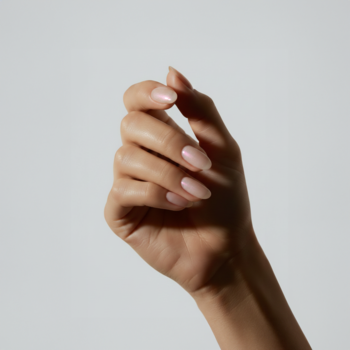 Ręka z paznokciami pomalowanymi lakierem COOLNAILS Rose Quartz Active Pen, z perłowym, rozświetlającym blaskiem.