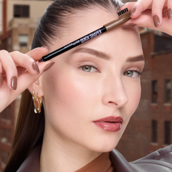 Kobieta z brązową kredką Quick Shaper Brow do stylizacji brwi, widoczną szczoteczką i logotypem, na tle miasta.
