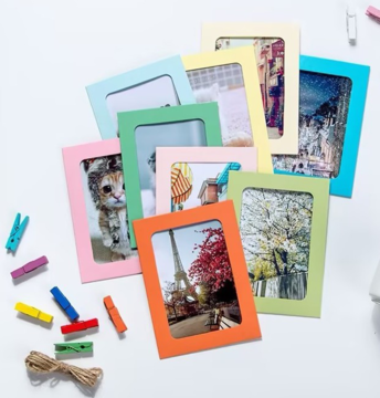 Happy Color ramki kartonowe na zdjęcia MIX kolorów 13x18cm, 10 sztuk, rozłożone na białym tle ze sznurkiem i spinaczami.