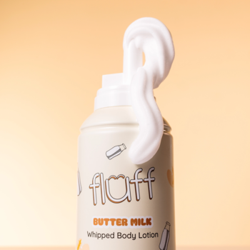 Balsam do ciała Fluff Butter Milk Whipped Body Lotion, biała puszka z puszystą pianką wychodzącą z dozownika.