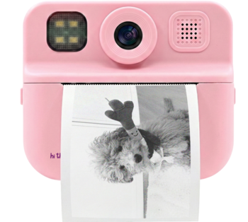 Różowy, kompaktowy aparat natychmiastowy z obiektywem i lampą, drukuje czarno-białe zdjęcie psa.