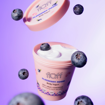 Fluff Blueberry Mochi Body Yogurt w różowym słoiku z otwartym wieczkiem i borówkami na fioletowym tle.