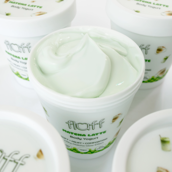 Fluff Matcha Latte Body Yogurt, otwarty biały słoik z jasnozielonym kremem, kilka opakowań.