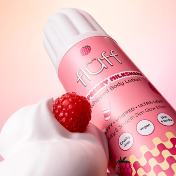 Zbliżenie na różowy balsam Fluff Raspberry Milkshake Whipped Body Lotion i biały ubity krem z maliną na gradientowym tle.