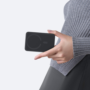 Czarny powerbank Baseus EnerFill FM11 z MagSafe w dłoni kobiety, widok z przodu, białe tło.