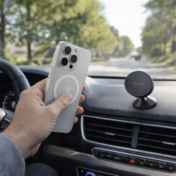 Ręka umieszcza iPhone’a z etui na czarnym, magnetycznym uchwycie samochodowym Baseus GoTrip DC1 na desce rozdzielczej.