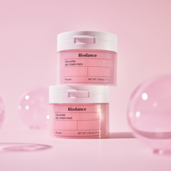 Dwa różowe słoiczki Biodance Collagen Gel Toner Pads, ułożone pionowo na różowym tle z przezroczystymi kulami.