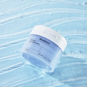 Biodance Bio-Collagen Real Deep Mask GEL TONER PADS w jasnoniebieskim słoiczku, na jasnoniebieskim, falującym żelu.