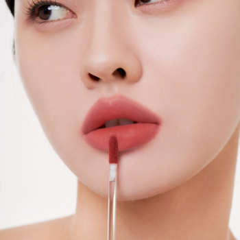 Zbliżenie: Muzigae Mansion lekki tint do ust Melted, matowe wykończenie, aplikator nakłada produkt na usta.