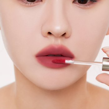 Zbliżenie na usta. Muzigae Mansion Lekki tint Pairing o matowym wykończeniu aplikowany na dolną wargę.