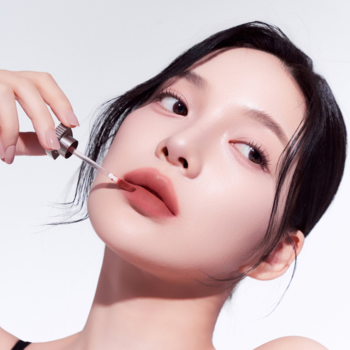 Zbliżenie: kobieta nakłada żelowy tint Muzigae Mansion Chocolat, podkreślając matowe, miękkie usta.