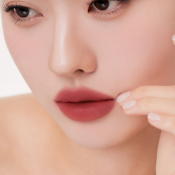 Zbliżenie na usta z matowym tintem Muzigae Mansion Affection. Delikatny, czerwonobrązowy odcień na ustach kobiety.