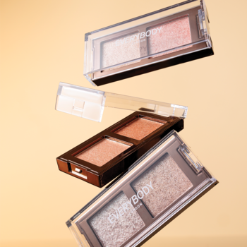 Trzy mini palety cieni Everybody London, w tym Soft Peach, z metalicznym blaskiem, uniesione na jasnym tle.