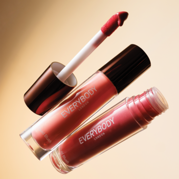 Dwa płynne róże Everybody London Flirty Apricot, brzoskwiniowo-różowe, jeden otwarty z aplikatorem, na ciepłym tle.
