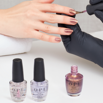 Manikiur z lakierem OPI Butter Me Up Toffee na dłoni, kremowy odcień toffi z brokatem, obok trzy butelki.