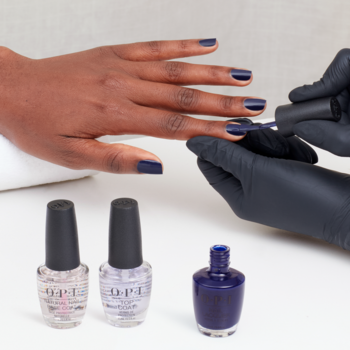 Lakier OPI Havin’ a Candy Ol’ Time, intensywny ciemnoniebieski, nakładany na dłoń. Widoczne buteleczki OPI.