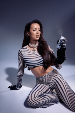 Modelka w paski, używająca Dewy Mist – mgiełki do twarzy dla promiennej, nawilżonej skóry z efektem mokrej cery.