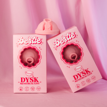 Dwa różowe dyski menstruacyjne Bestie Dysk z medycznego silikonu w opakowaniach, jeden na wierzchu, na różowym tle.