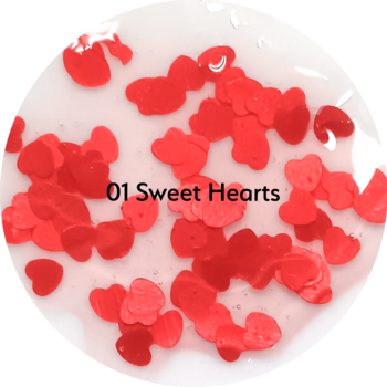 Czerwone konfetti w kształcie serc na przezroczystym żelu, z napisem '01 Sweet Hearts' na środku. Zbliżenie.