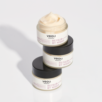 Trzy słoiczki kremu na noc Veoli Botanica Repair By Night, ułożone pionowo. Górny otwarty, ukazujący beżowy krem.